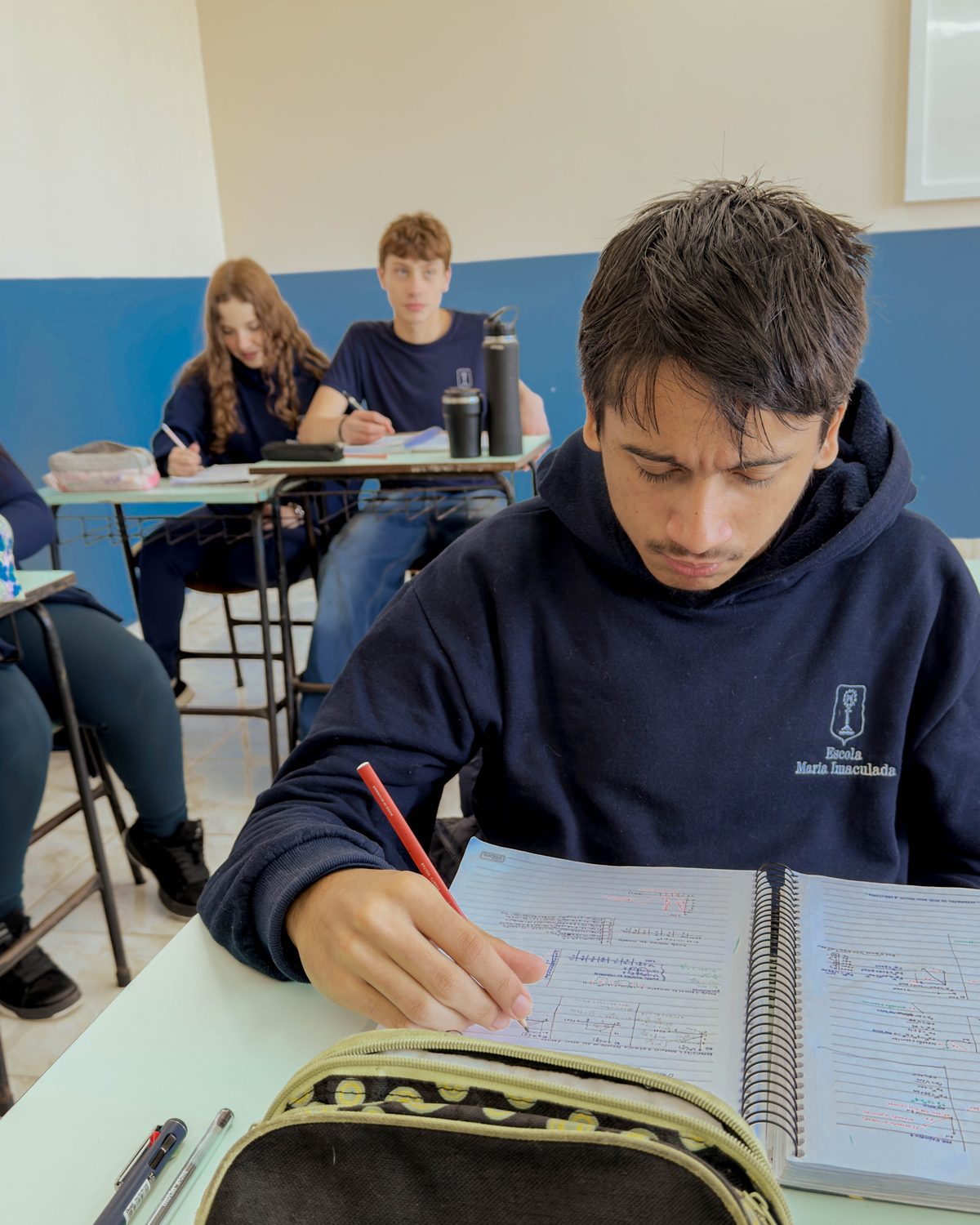 Estudante do Ensino Médio fazendo anotações em sala de aula